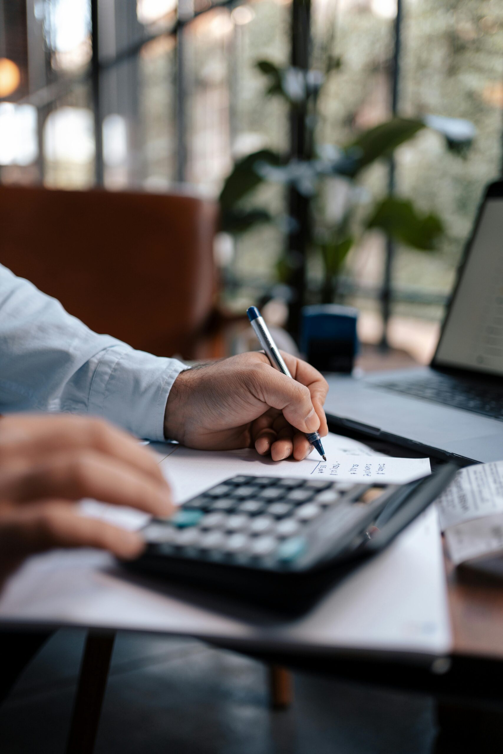 Home 25 Free A Person Calculating Finances With A Calculator And Pen On A Desk Indoors. Stock Photo