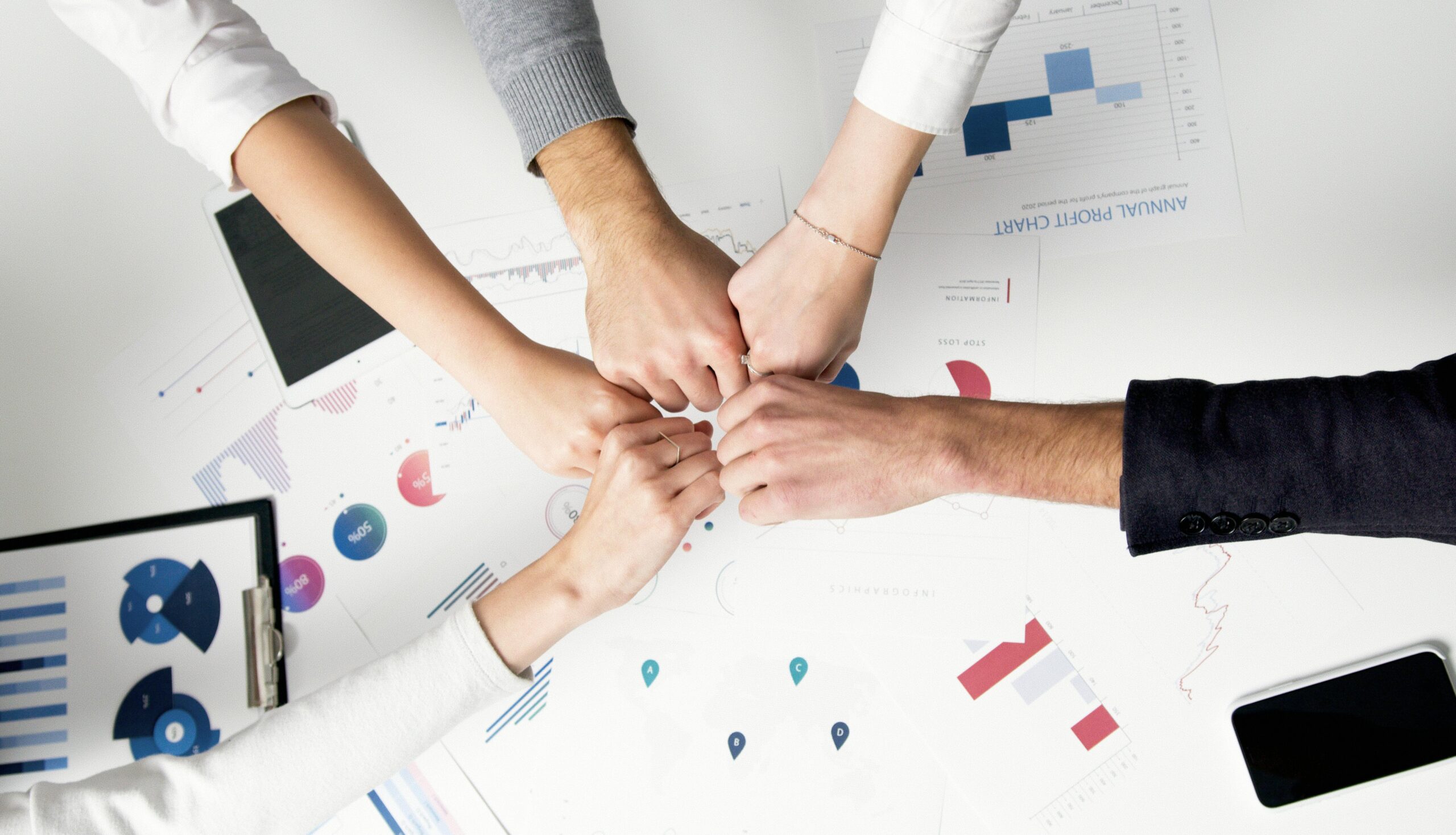 Home 25 Free Colleagues Celebrate Success With A Fist Bump Over Financial Charts Depicting Teamwork And Unity. Stock Photo